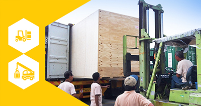 Workers driving forklift to load heavy cartons.