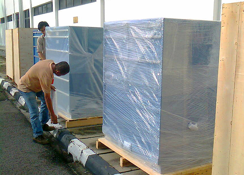 Popular Pack workers are wrapping machine for shipping.